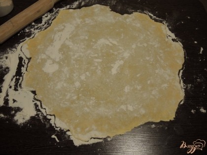 Просыпаем немного муки на стол и начинаем раскатывать тесто в тонкий блин. В результате диаметр такого блина должен составить порядка 50-60 см.