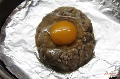 Сделать в средине отверстие и аккуратно вбить яйцо чтобы сохранить целым яичный желток.