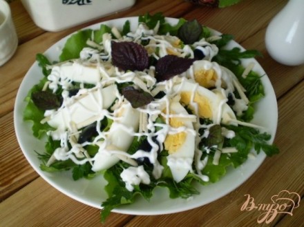 Салат с яйцом, листьями салата, маслинами и базиликом